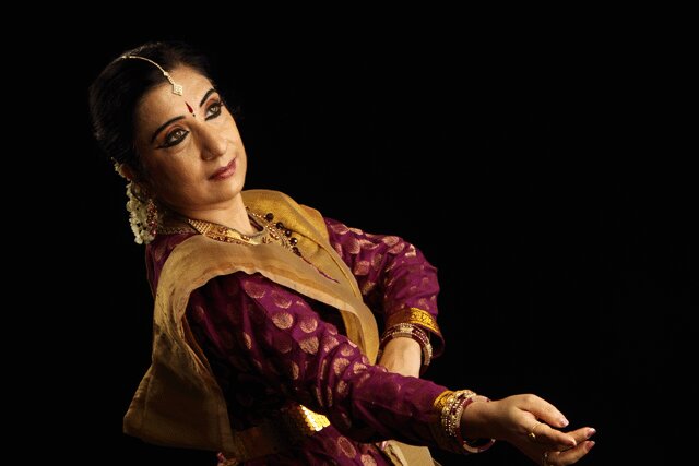 Sushmita Banerjee in performance, in magenta and gold